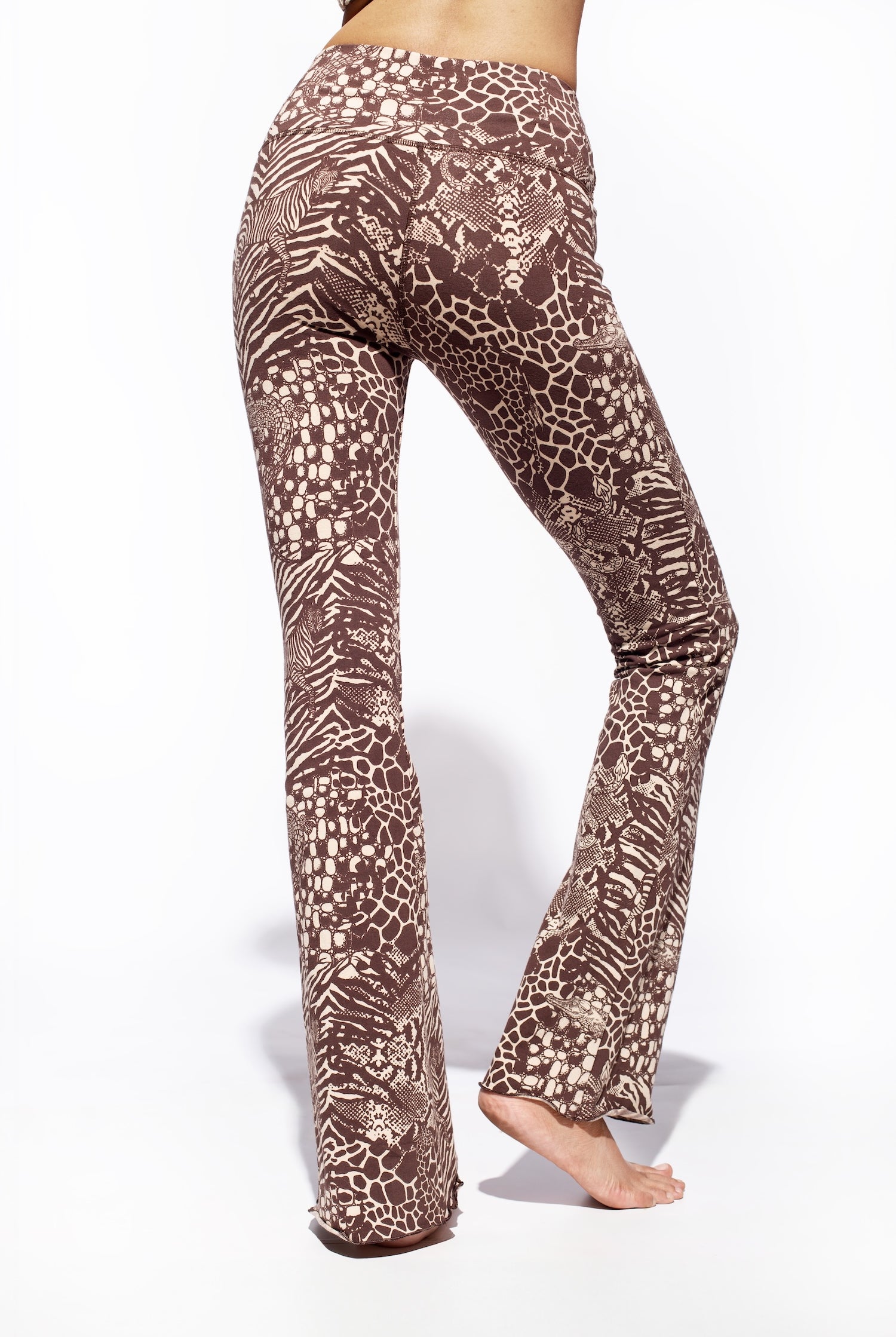 A woman wearing Funky Simplicity wild animal-print flared leggings in cream brown color shown from the back.