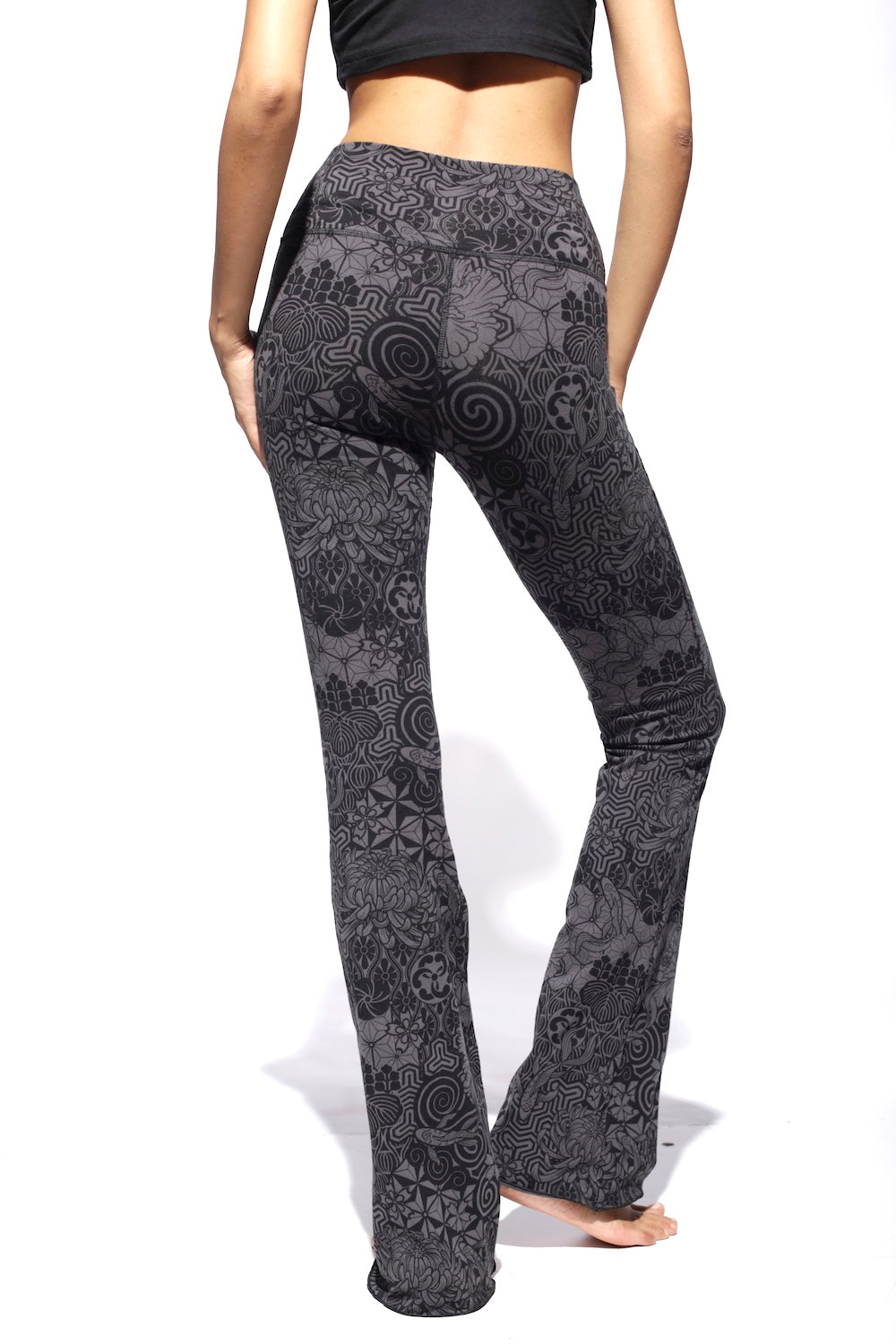 A pair of gray and black flare leggings with a geometric pattern, featuring a high waist and bootleg cut.
