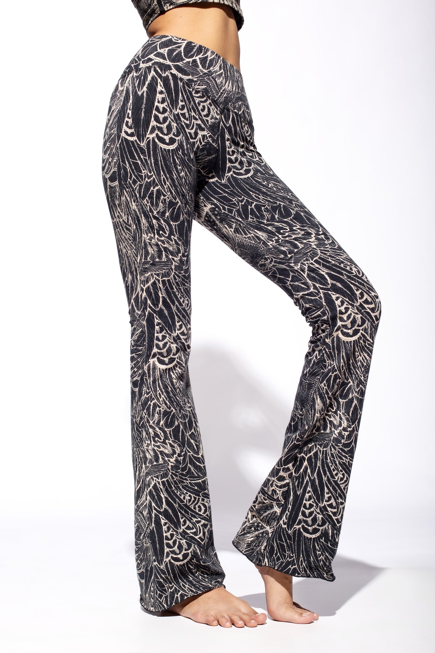 Woman wearing Feather Cream Black Flares seen from the side close up.