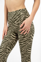 Woman wearing cream and olive zebra print high-waist leggings in comfortable cotton elastaan fabric from Funky Simplicity - perfect for yoga, fitness, and loungewear. Close-up